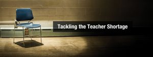 empty chair with spotlight on it in front of a chalkboard