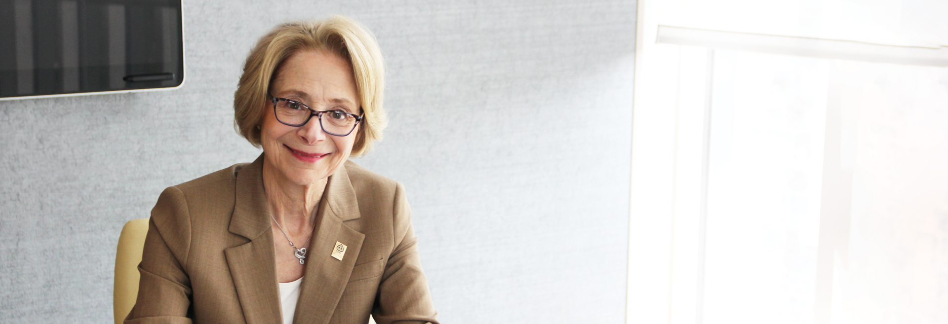 Dr. Karen Cortellino posing and smiling at the camera in a conference room