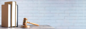 Featured art with a gavel and books in front of a brick wall