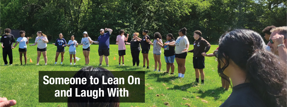 Featured image of high school kids holding hands in a circle outside in the grass