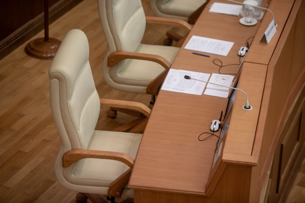 Empty chairs in a conference room with microphones on the tables