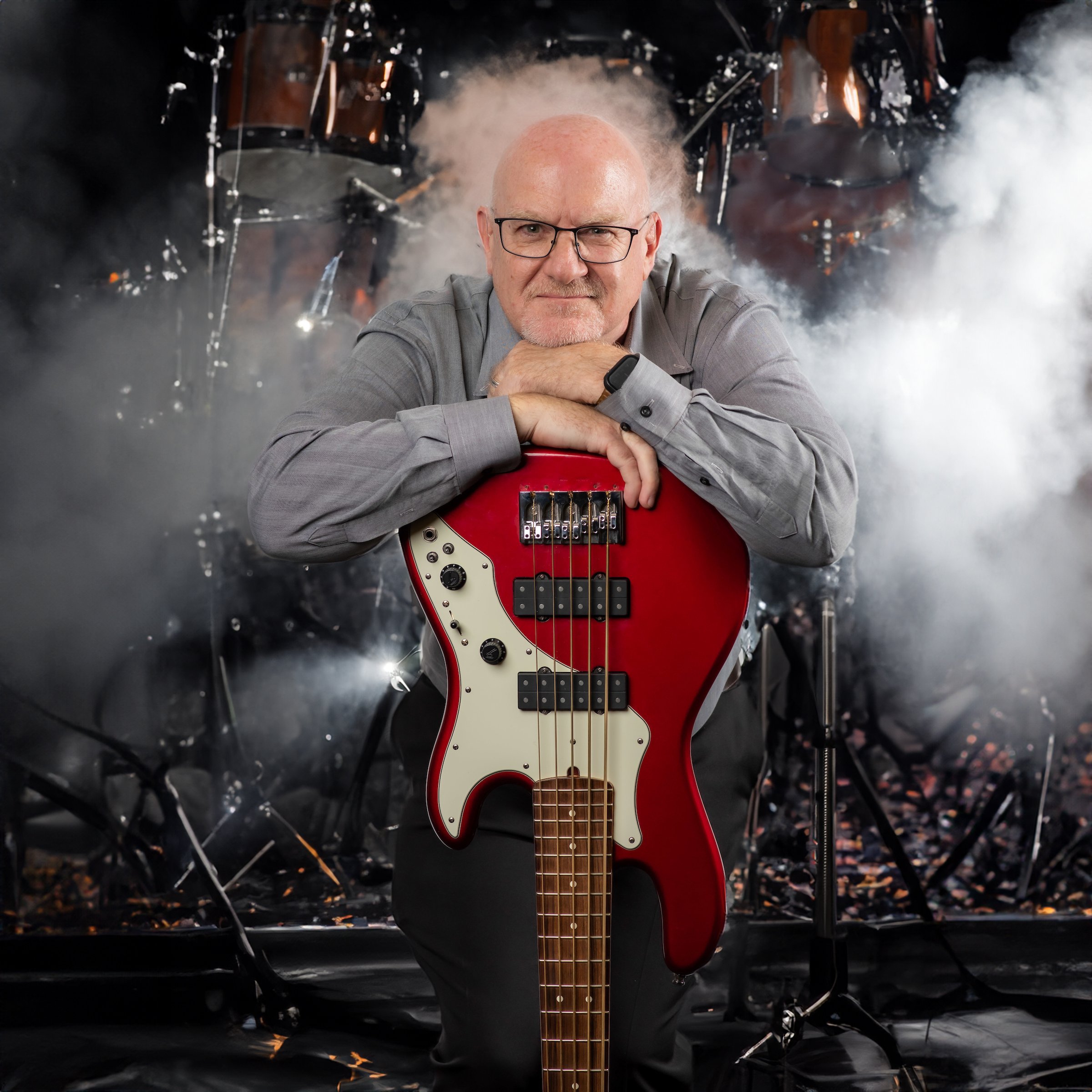 Lon Freeman fun photo leaning on an upside down guitar with a stage in the background