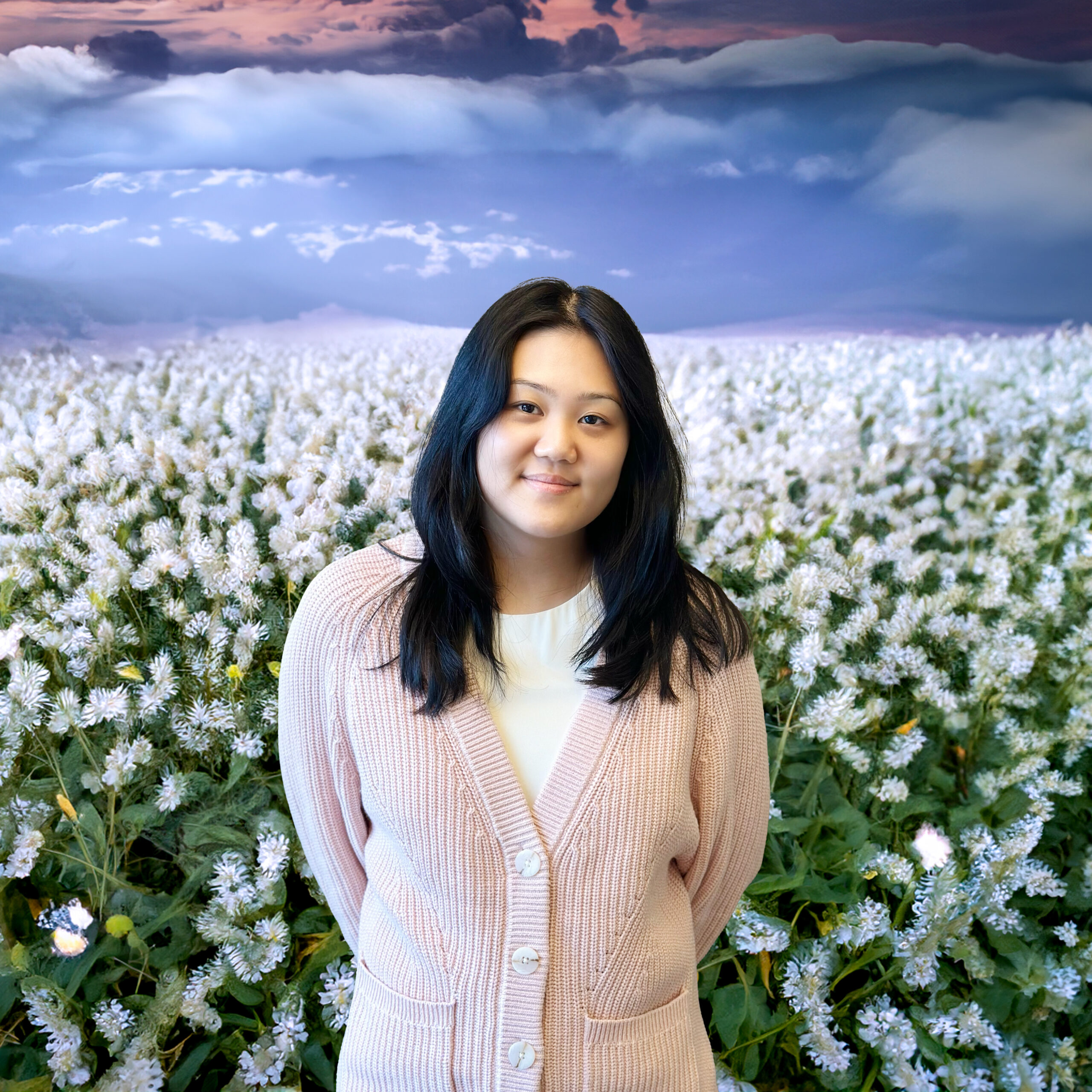 Lauren Liu in a field with cats in the sky