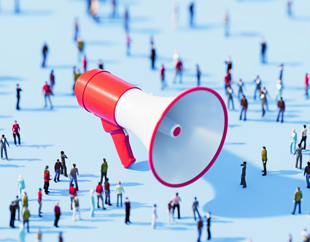 Human crowd surrounding red megaphone object on blue background. Horizontal composition with copy space.