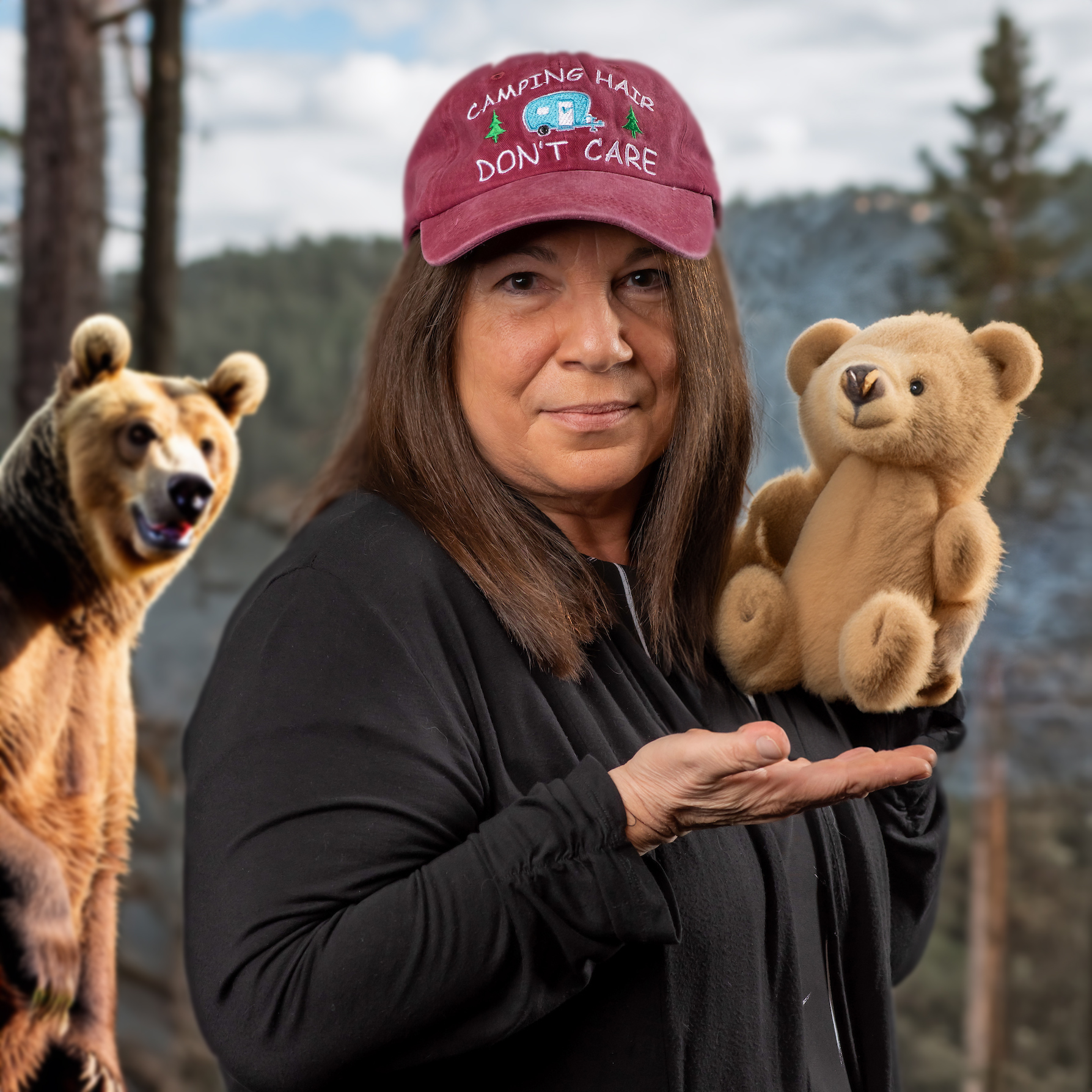 Sandy Raup posing with a stuffed teddy bear wearing a hat that says 