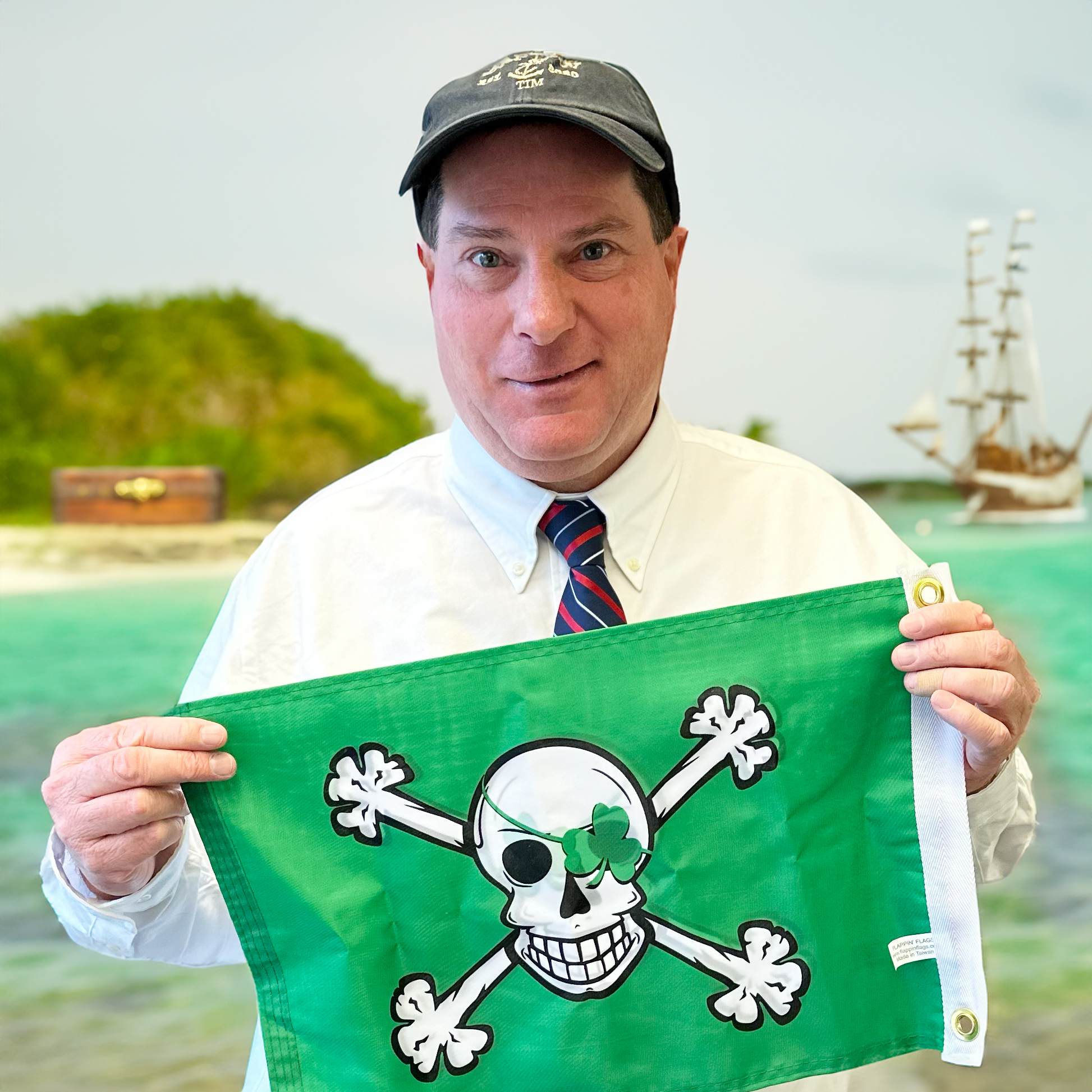 Tim Teehan holding an Irish pirate flag and a deserted island and pirate ship in the background