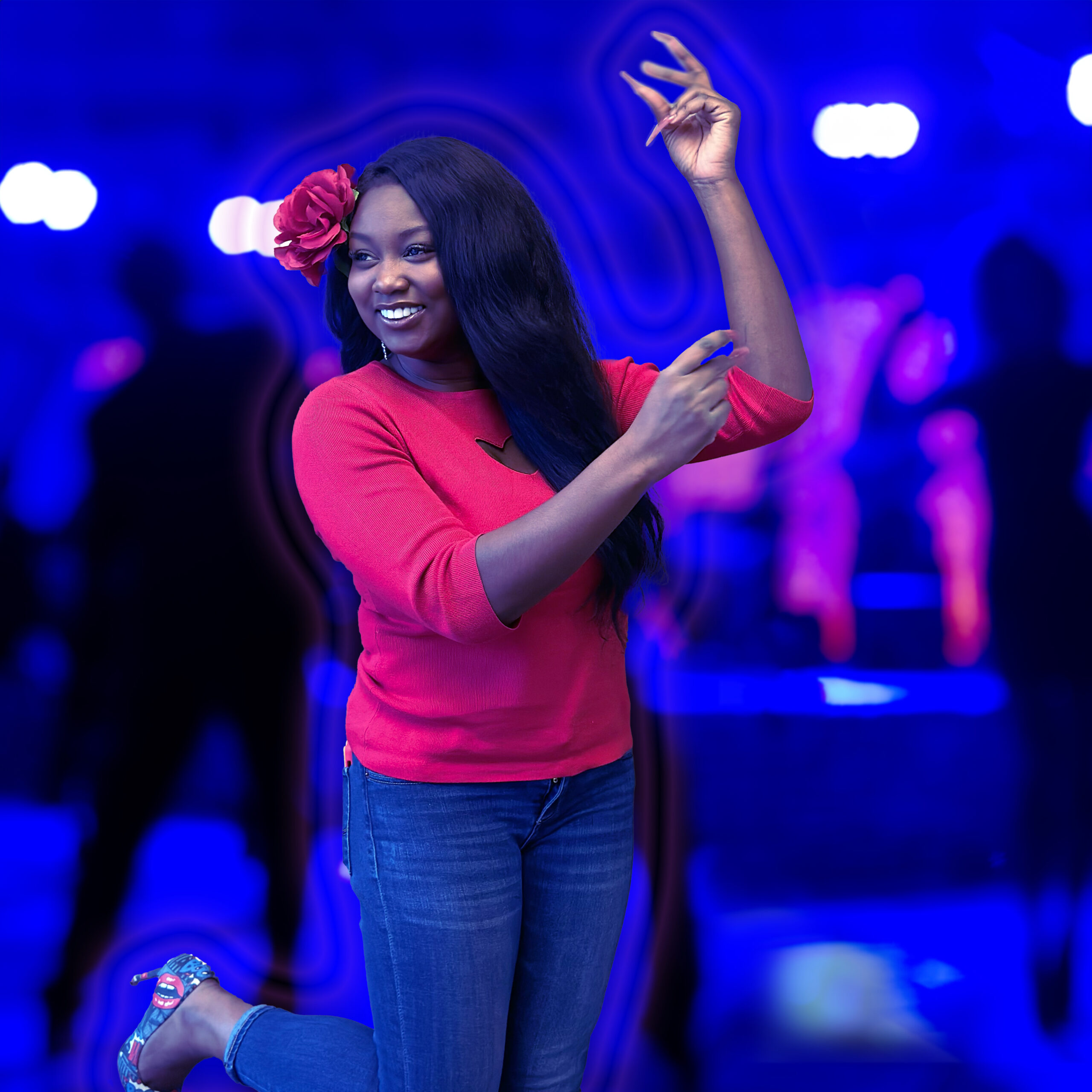 Felicie Tsogbe in a dance pose with a dark dance floor in the background