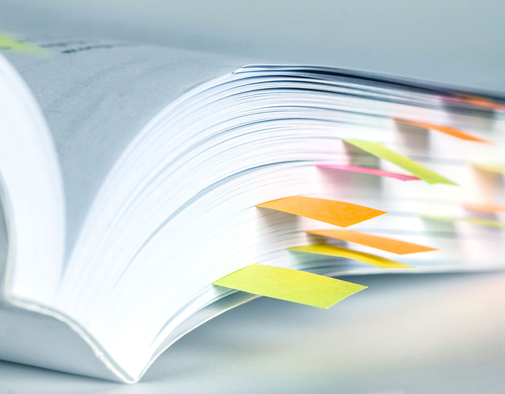 closeup of the binding of a book with sticky note tabs