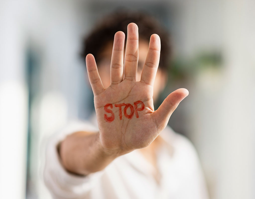 Student holding up their hand with the word stop written on it