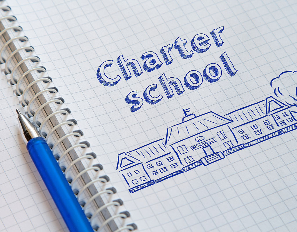 notebook doodle of the words charger school and a school building