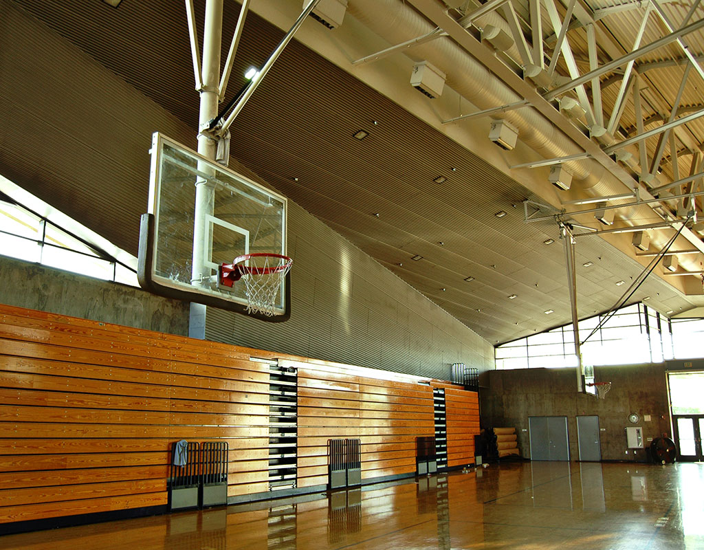 wide angle view of an empty school gym with a basketball court