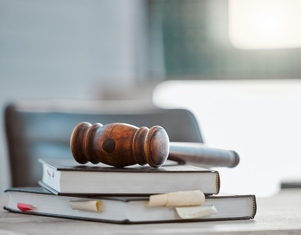 stack of books on a desk with a gavel sitting on top