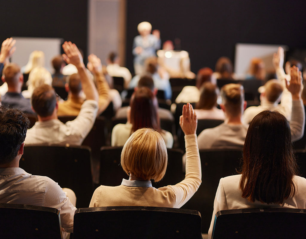 adults in a training session with their hands raised