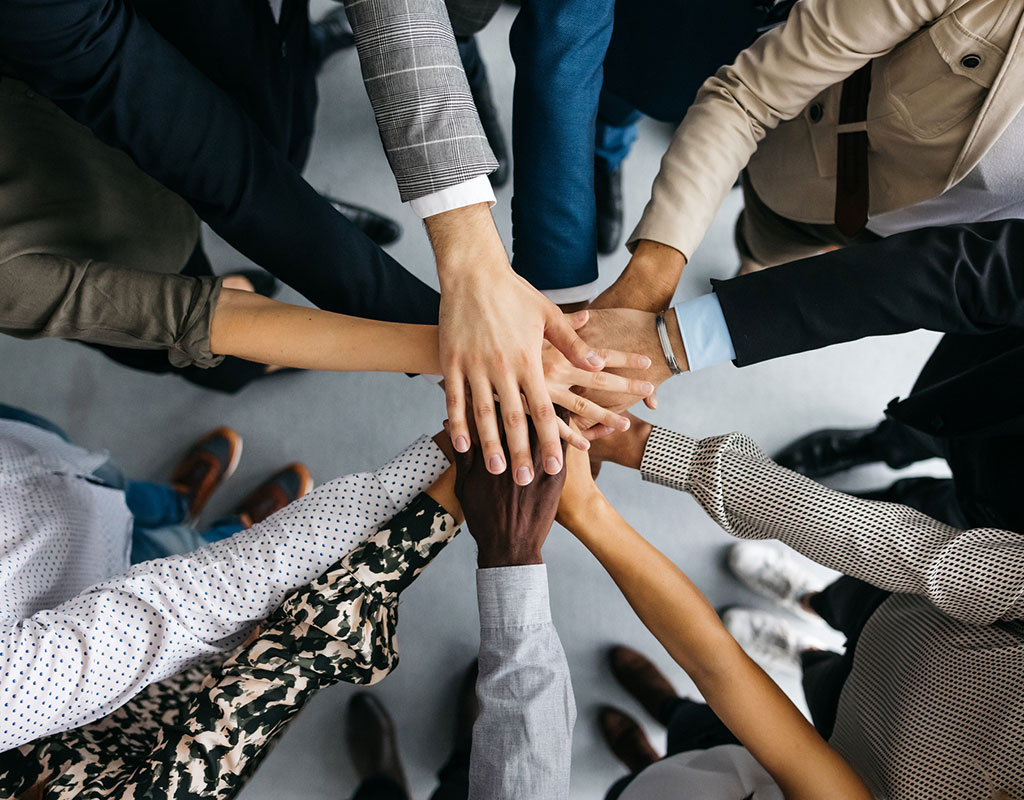 closeup circle of diverse hands stacked on each other