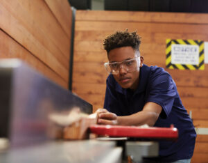 teenage student working in a wood shop