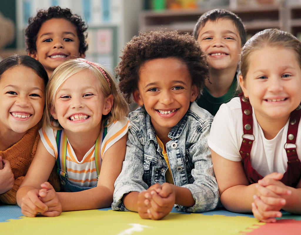 Group of diverse middle school students in a classroom posed and smiling