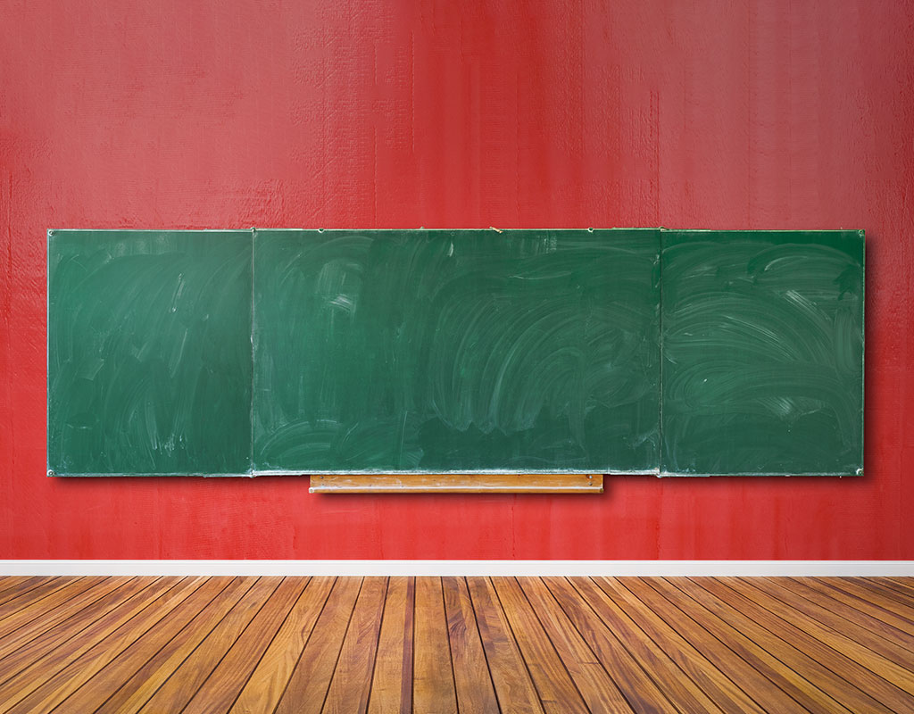 Blank chalkboard in an empty classroom