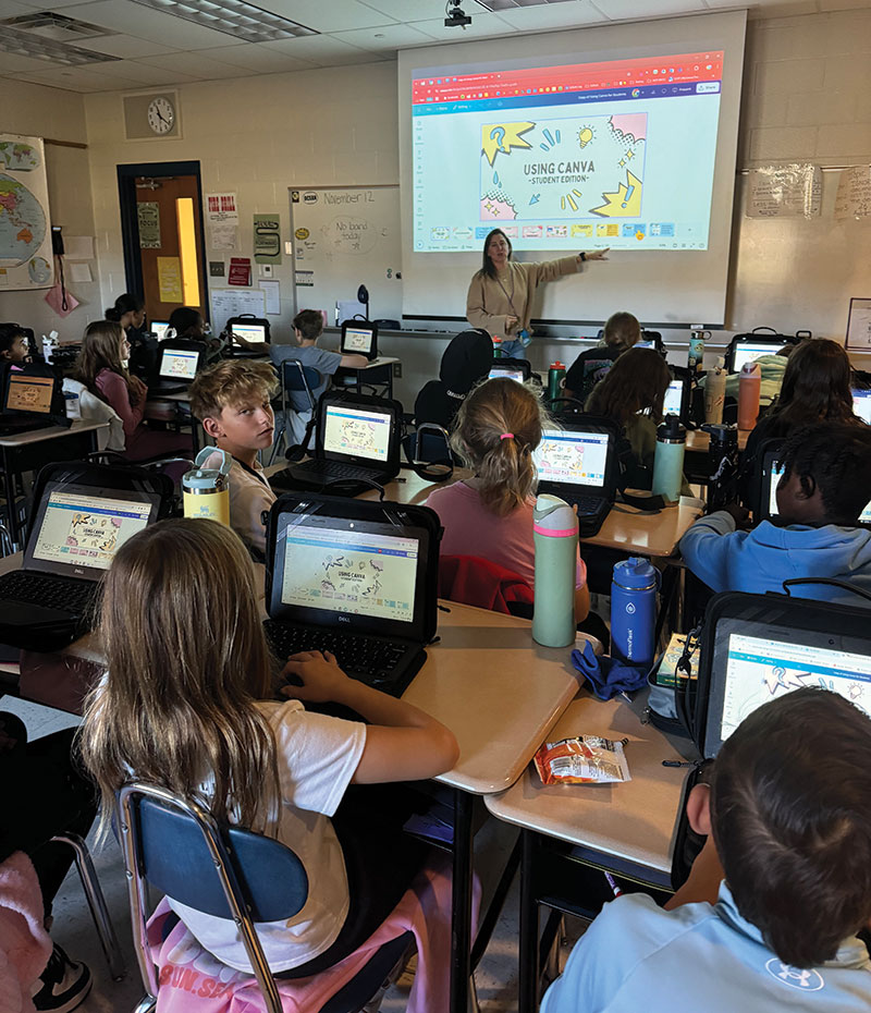 group of students in a classroom looking at a projector screen